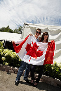 People holding up a Canadian Flag at a celebration